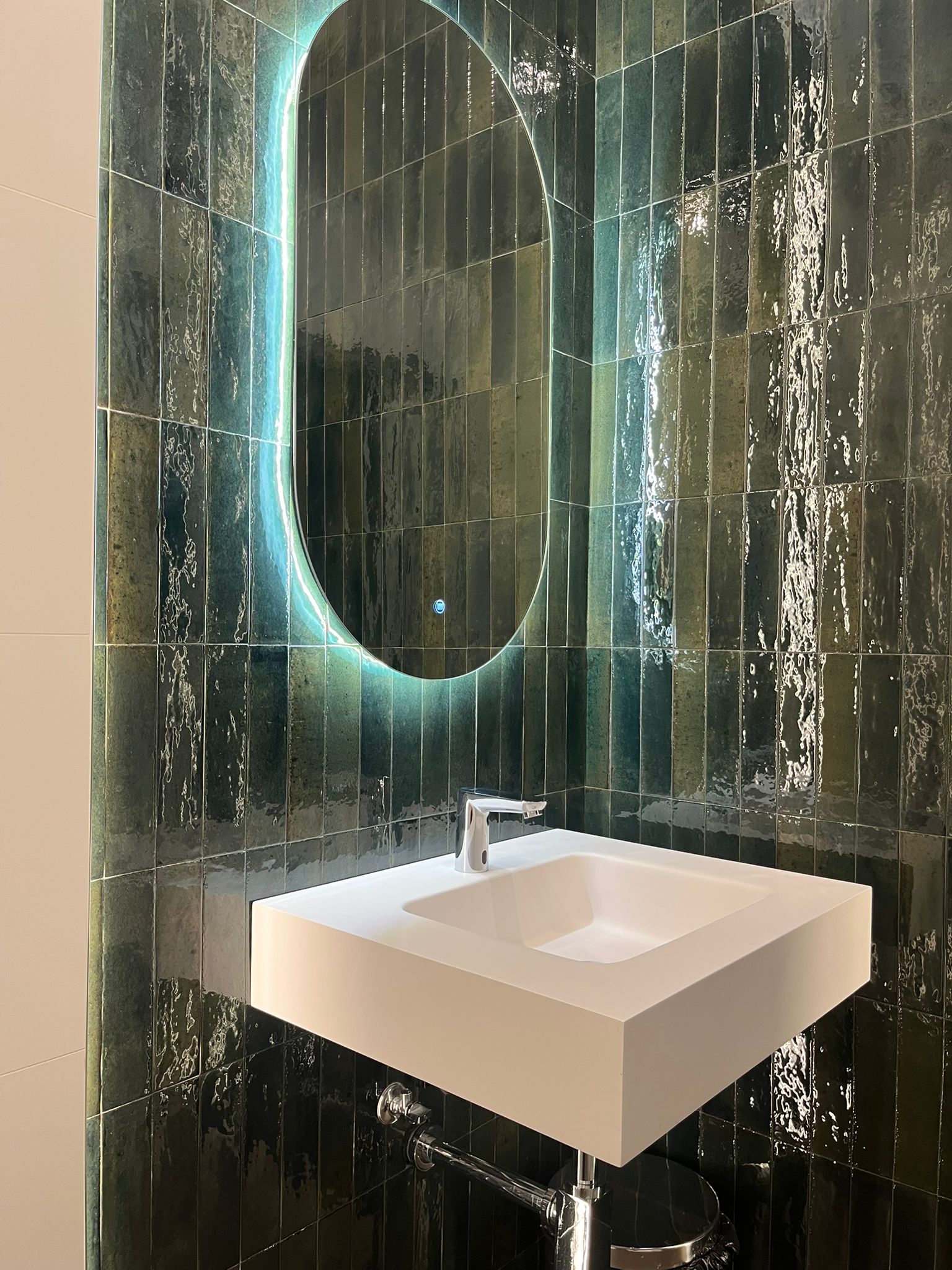 Baño de diseño con revestimiento cerámico esmaltado verde esmeralda y lavabo moderno