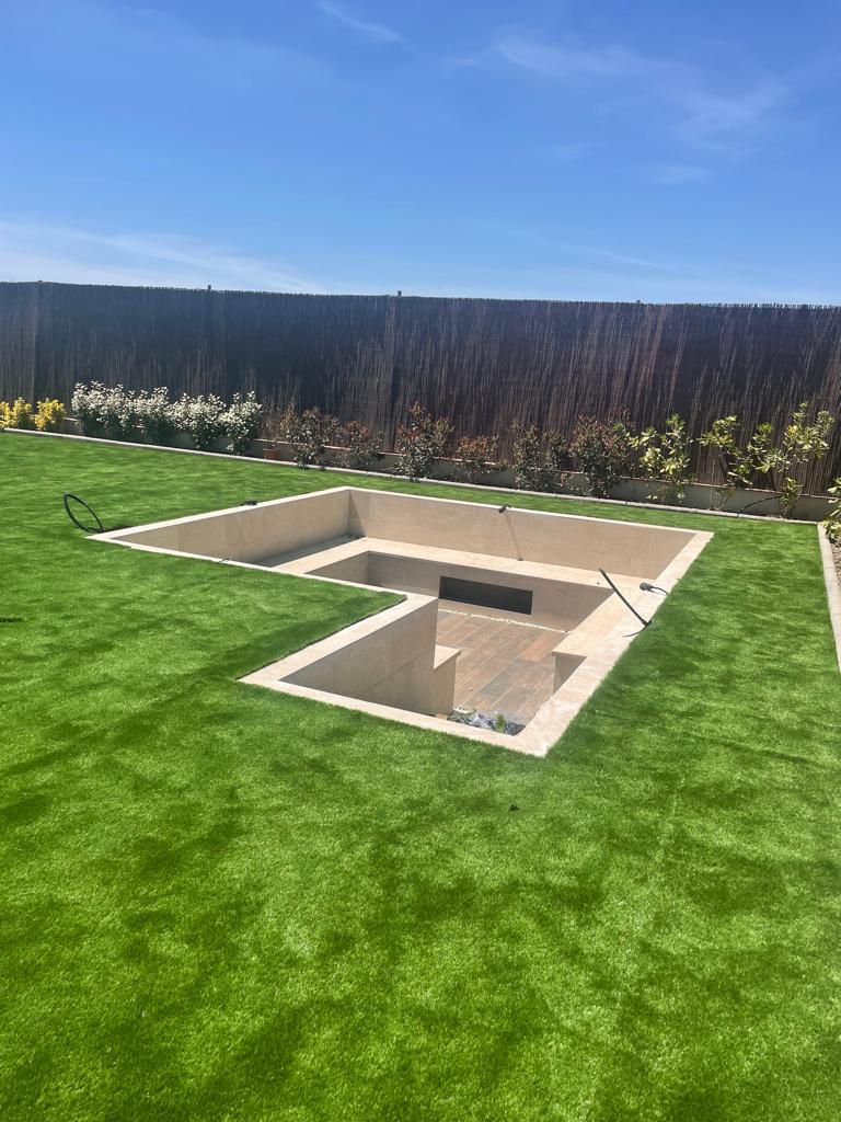 Foso chill out exterior revestido con cerámica gran formato arena y suelo porcelánico efecto madera