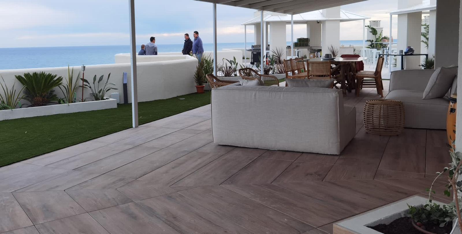 Gran terraza cubierta con suelo en espiga y vistas al mar