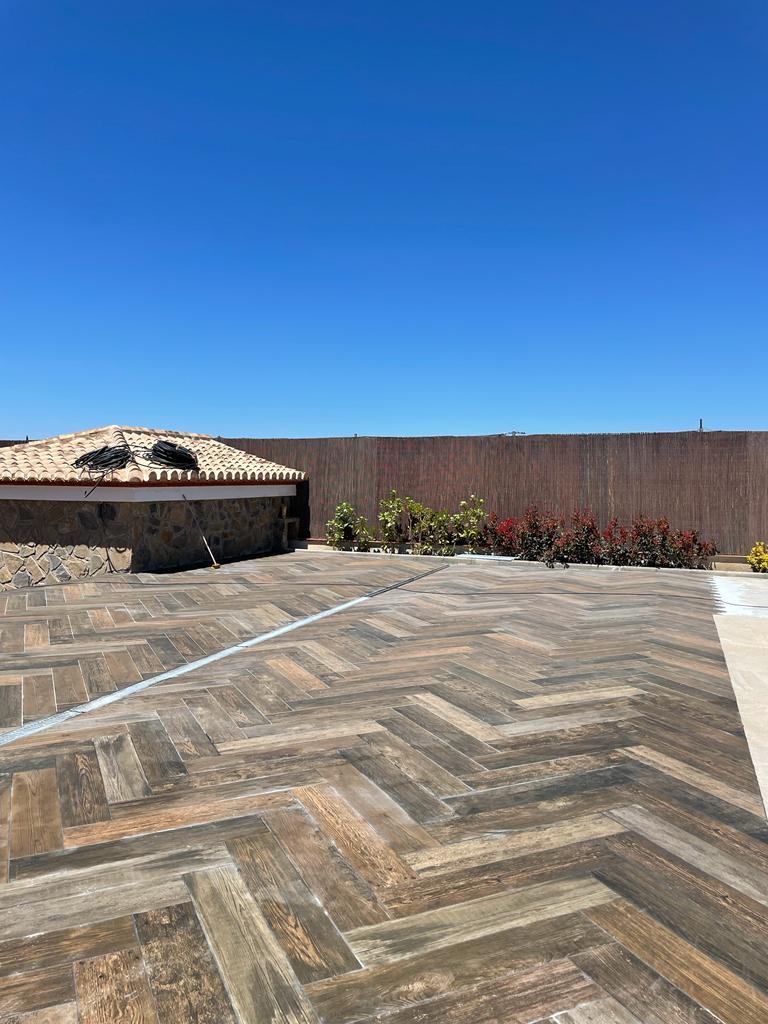 Patio exterior pavimentado en madera espiga