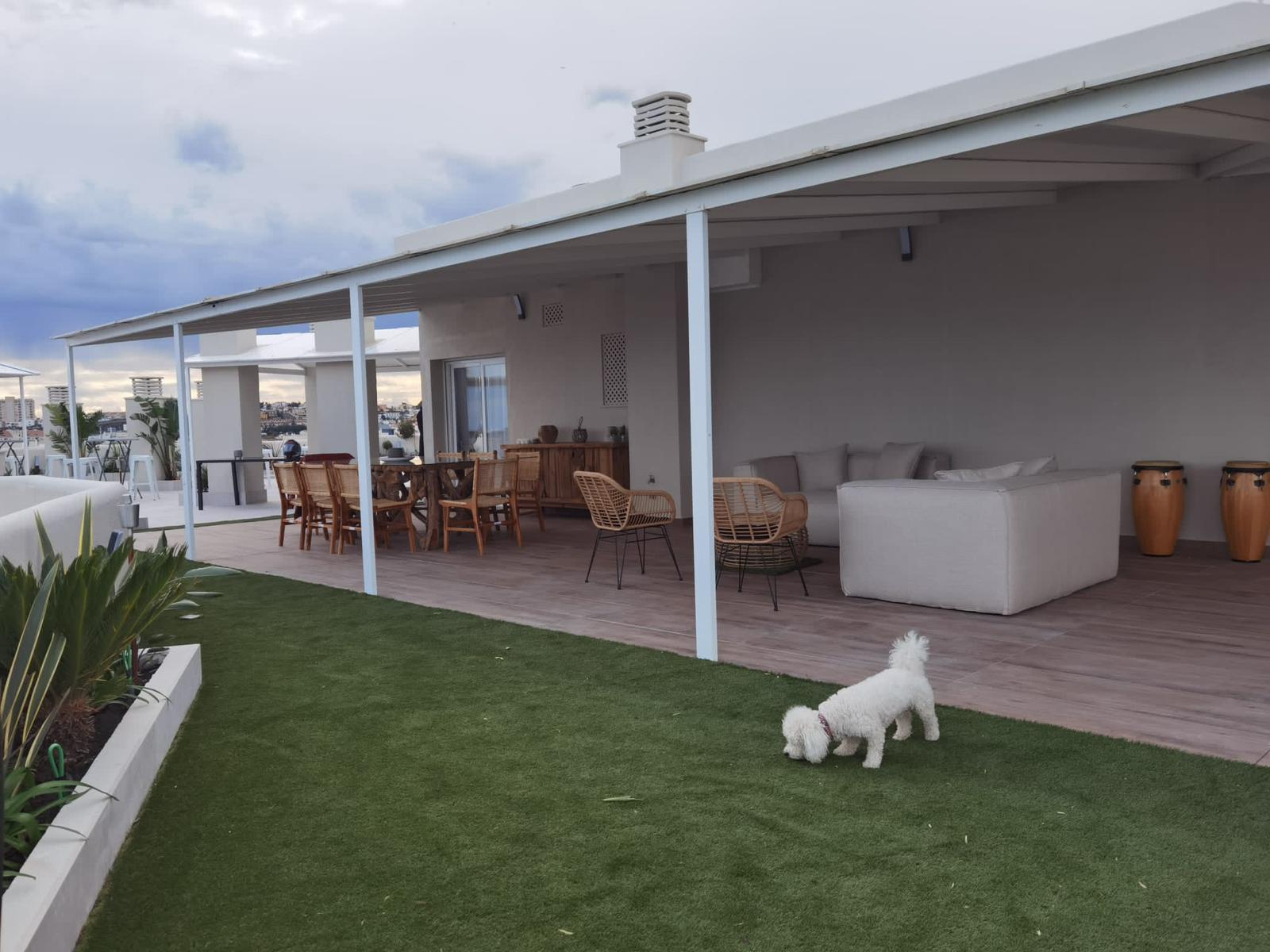 Porche cubierto con sofás y suelo de madera